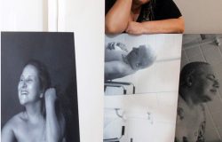 Kica de Castro com algumas telas de sua exposição fotografica