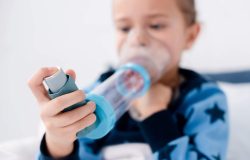 selective focus of asthmatic kid using inhaler with spacer at home