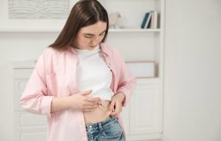 Mulher aplicando insulina sob a pele da barriga