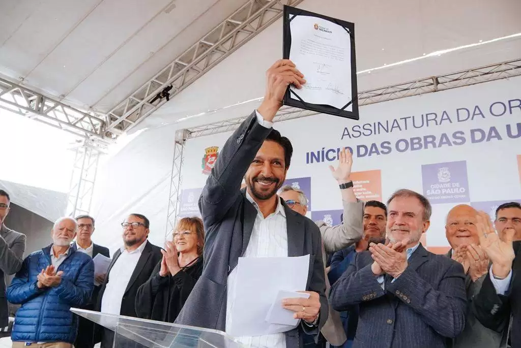 Nova unidade Básica de Saúde UBS Primavera Colorado terá capacidade para 3.800 atendimentos mensais. Os moradores da região Primavera/Colorado, em Sapopemba na Zona Leste, conquistaram um sonho aguardado por 30 anos. O prefeito de São Paulo, Ricardo Nunes, assinou nesta quarta-feira (9) a ordem de serviço para o início das obras “Aqui não será uma UBS qualquer, estamos trabalhando para que seja a UBS Primavera Colorado, com o investimento de quase R$ 9 milhões para a construção de um prédio com estrutura para fazer um excelente atendimento aqui para a comunidade. Uma obra que já está com o dinheiro em conta, licitada, com projeto aprovado para que as obras sejam iniciadas”, disse o prefeito Ricardo Nunes. O documento foi assinado no local onde a UBS Primavera Colorado será construída, na rua Antônio Ribeiro Macedo, 264, no bairro Jardim Porteira Grande. O investimento para a implantação será de cerca de R$ 9 milhões, com recursos do Fundo Municipal de Saúde (FMS) e previsão de entrega em 18 meses. “Essa é uma UBS que estará mais próxima dos moradores aqui da região, para atender quase quatro mil pessoas por mês com equipes de Estratégia da Saúde da Família, duas equipes de odontologia, além de uma equipe multiprofissional com psicólogos, nutricionistas, tudo para fazer os acompanhamentos necessários, como dos diabéticos e hipertensos, para impedir que as pessoas tenham complicações. Este é o avanço da saúde do município de São Paulo”, destacou o secretário municipal de Saúde, Luiz Carlos Zamarco. Estrutura A UBS Primavera Colorado será do tipo IV e contará com cinco equipes de Estratégia de Saúde da Família (ESF), duas equipes de saúde bucal e ainda médico generalista, equipe de enfermagem, agentes comunitários de saúde, farmacêutico, assistente social, técnico de farmácia, assistente administrativo, dentista e auxiliar de saúde bucal. Além disso, o futuro equipamento vai disponibilizar coleta de exames laboratoriais, medicação, inalação, odontologia com raio-x, vacina, curativo e visitas domiciliares das equipes de ESF. A unidade será construída em uma área de 1.126 m² e estrutura com seis consultórios, duas salas de ginecologia, uma sala para atendimento ao idoso, uma sala de odontologia com quatro cadeiras, observação adulta e infantil; Unidade de Vigilância em Saúde (Uvis), sanitário acessível e elevador. “Esta é uma reivindicação antiga, que acompanhamos de perto e hoje estamos aqui, com muita alegria e satisfação, tendo a honra de iniciar para vocês essa unidade, que será muito importante para todos os moradores deste território”, afirmou a secretária executiva de Atenção Básica, Especialidades e Vigilância em Saúde, Sandra Sabino.